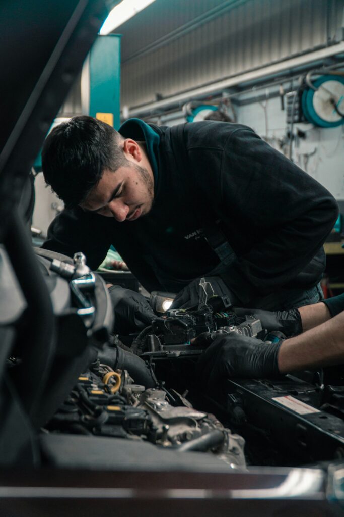 Automotive repair shop with a guy fixing something under the hood